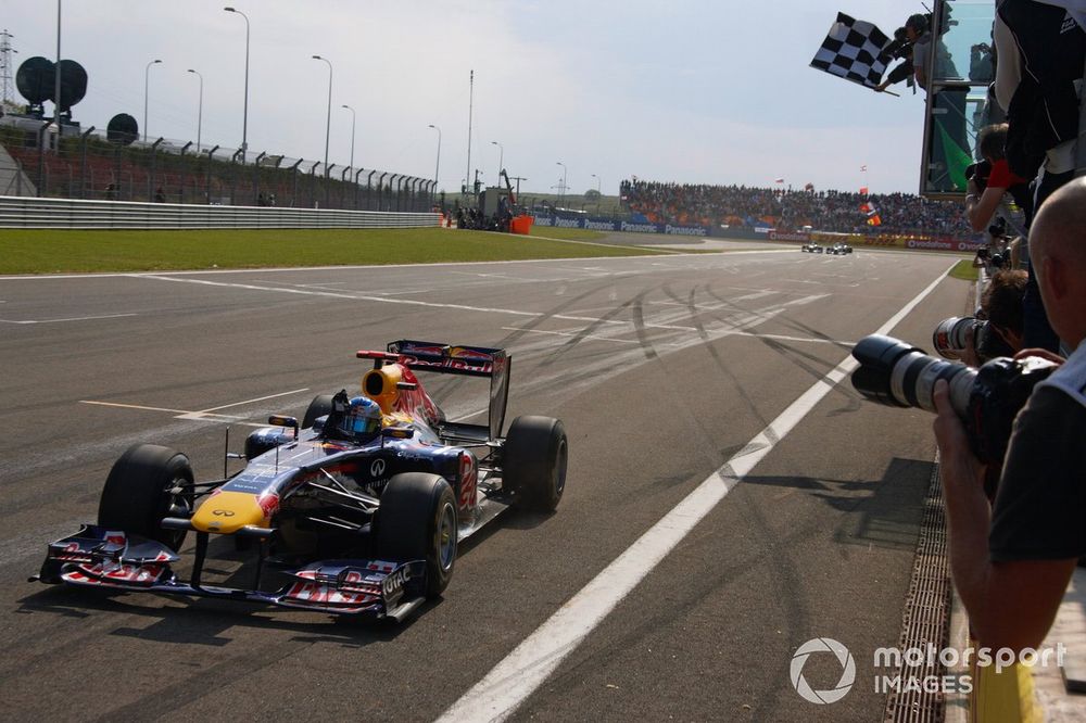 Sebastian Vettel, Red Bull RB7 Renault, crosses the finish line and takes the chequered flag