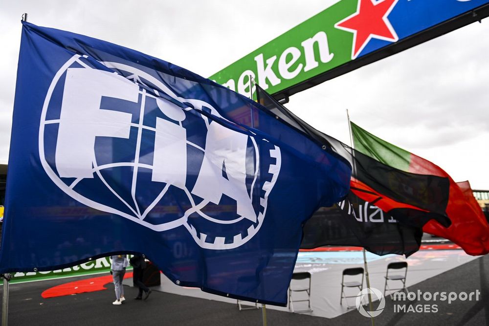 A huge FIA flag flies on the grid