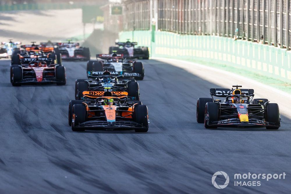 Lando Norris, McLaren MCL60 battles with Max Verstappen, Red Bull Racing RB19 at the start of the race