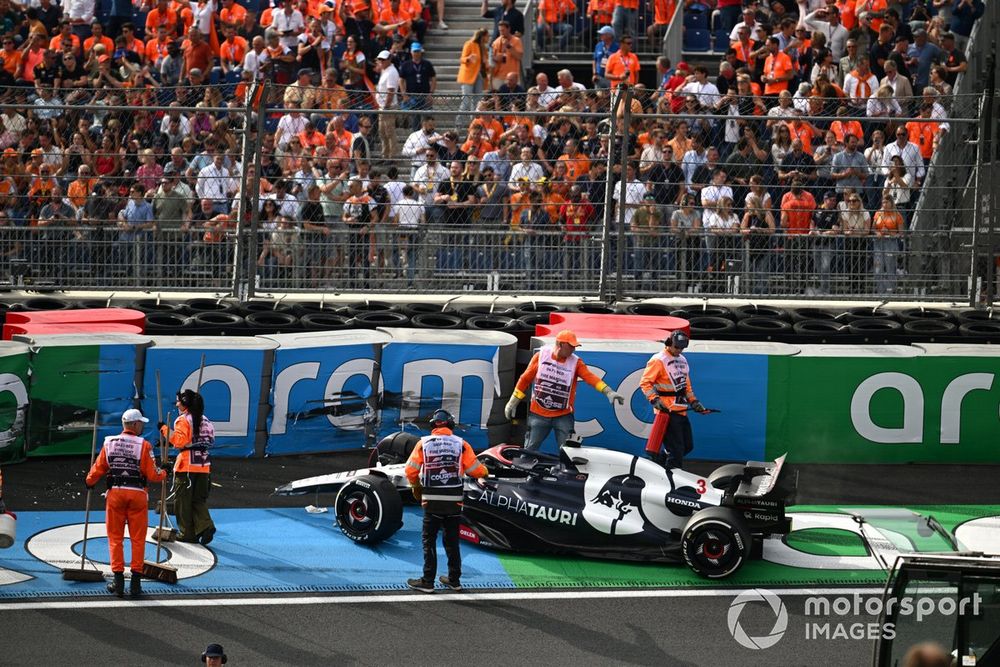 Marshals deal with the damaged car of Daniel Ricciardo, AlphaTauri AT04
